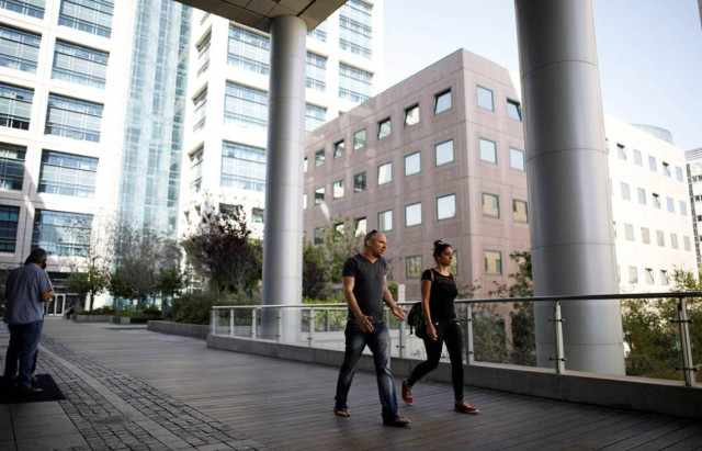 People walk near high-rise buildings in the high-tech business area of Tel Aviv, Israel May 15, 2017